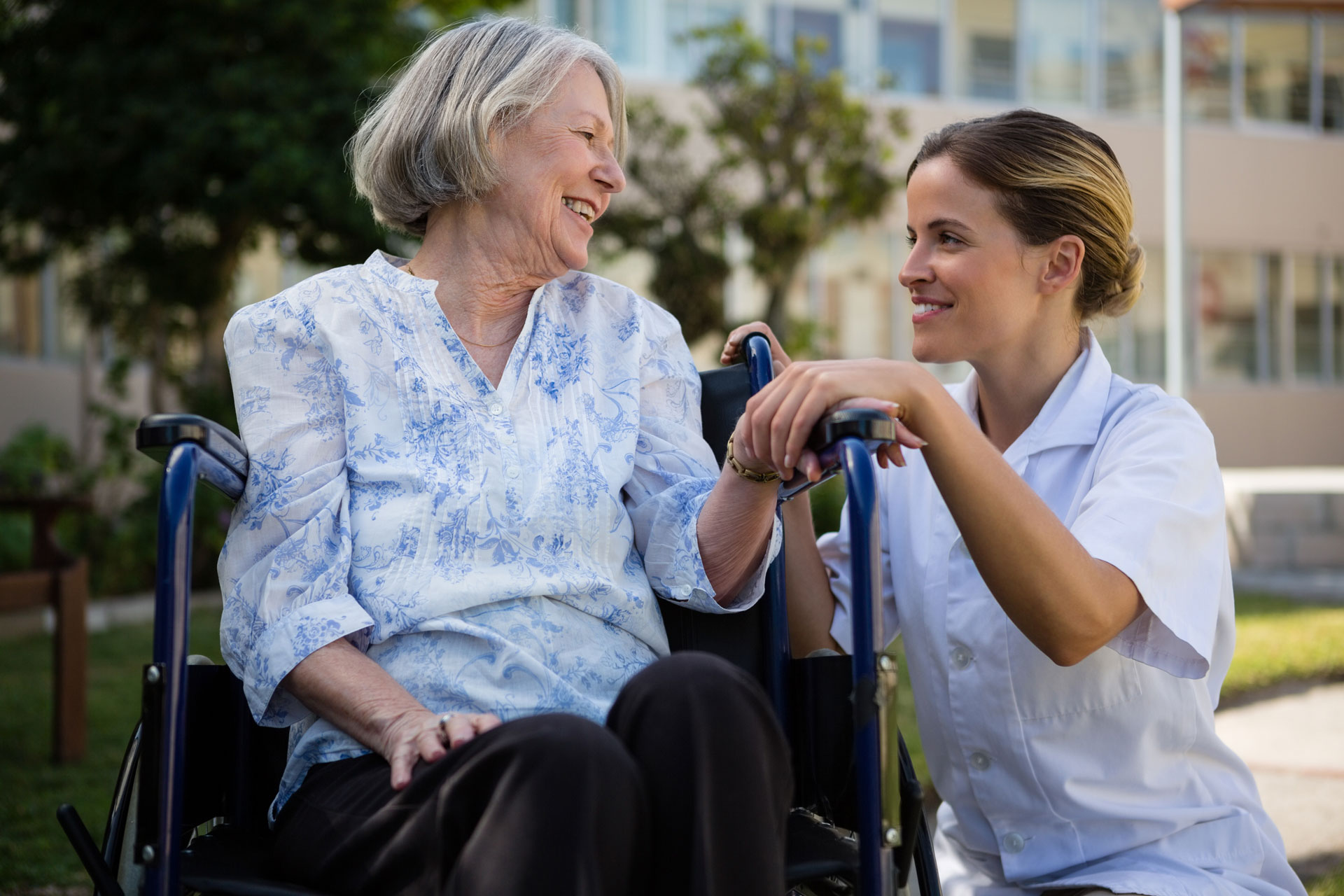 staff kneeling down to converse with resident