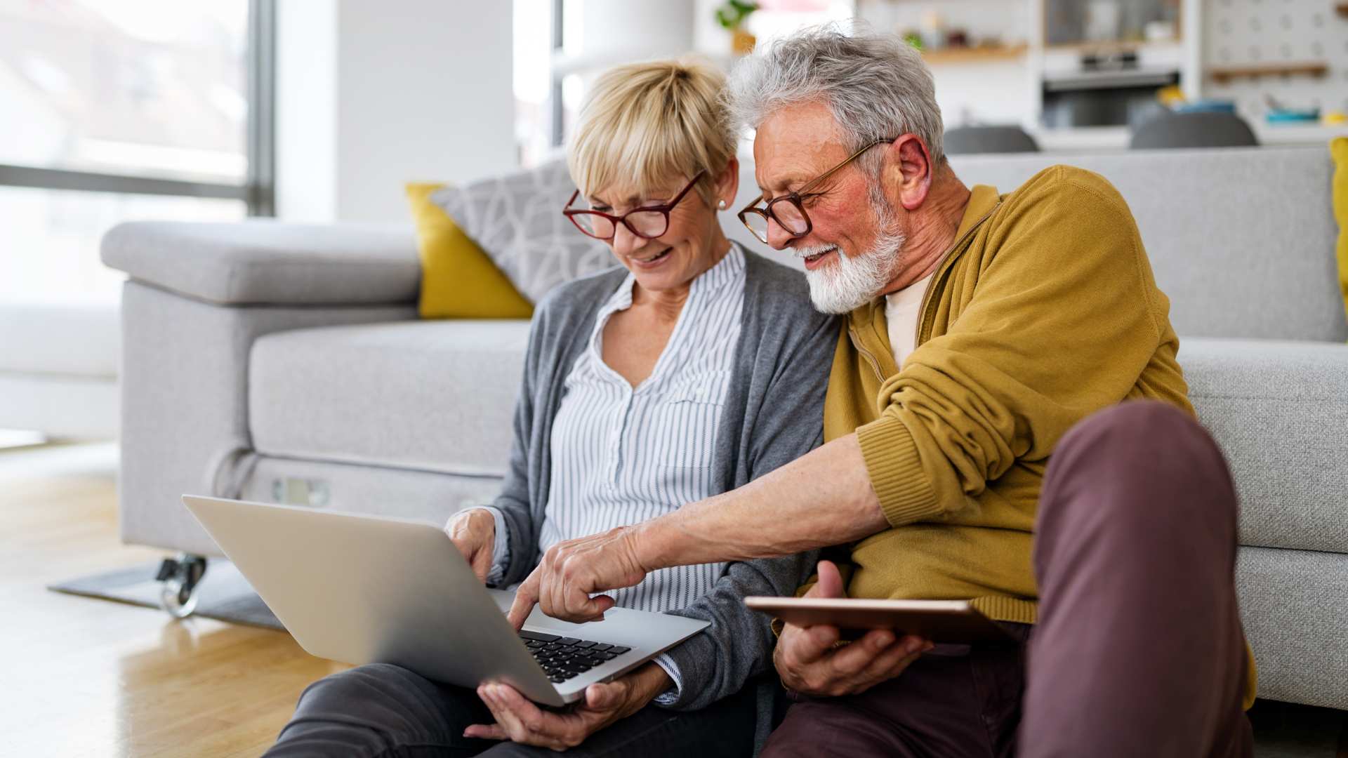 cheerful senior couple using technology devices together