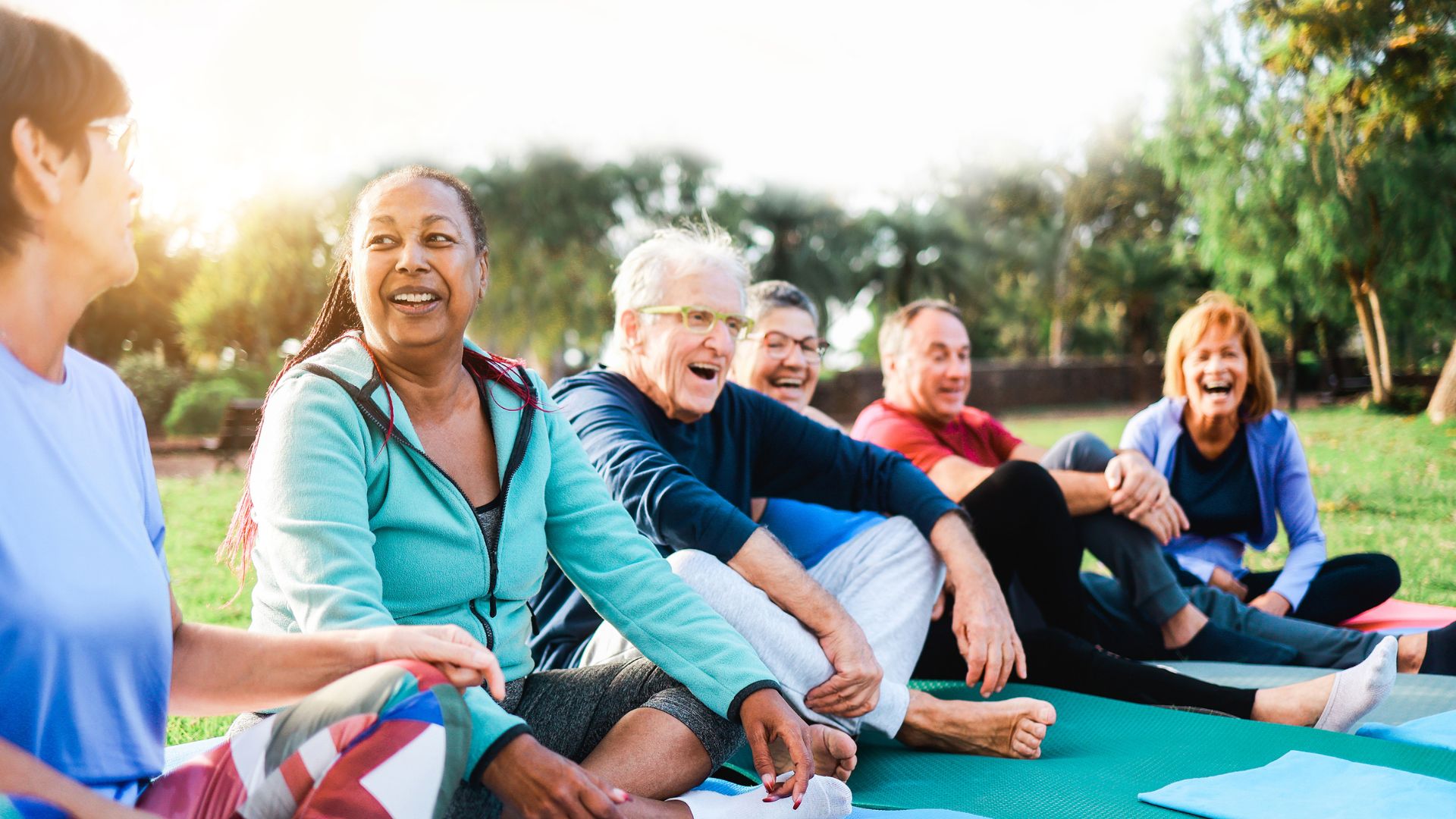 Happy senior people after yoga class having lunch outside